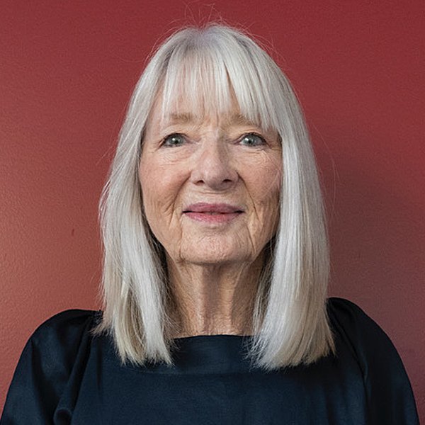Board member Carol Stott biography page. A woman with shoulder length white hair with a fringe.